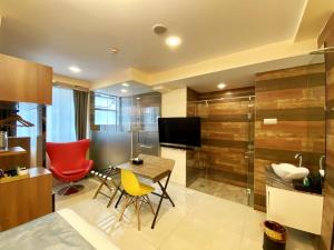 a living room with a table and chairs and a television at five6 Hotel Splendour in Singapore