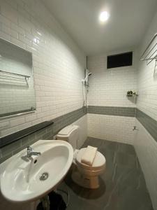 楠府的住宿－น่านลอฟท์รูมแอร์พอร์ต，白色的浴室设有水槽和卫生间。