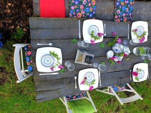 una mesa con platos blancos y sillas. en Szary Domek 1 jacuzzi komienk sauna klimatyzacja jezioro en Piotrków Kujawski