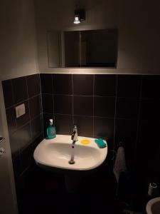 lavabo blanco en el baño con espejo en Living, en Milán