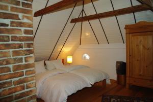 a bed in a room with a brick wall at Das Reetdachhaus - Paulines Höft in Grömitz