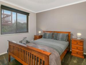 a bedroom with a wooden bed and a window at Red Rocks Villa in Cowes