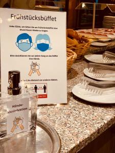 a sign on a counter with plates of food at Hotel Jakob in Groß-Umstadt