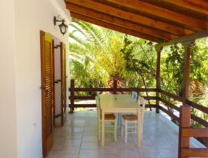 a patio with a white table and chairs on it at Bungalow Gialova in Gialova