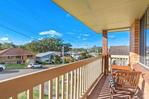 a porch with a wooden bench on a balcony at Location @ Little Beach in Nelson Bay