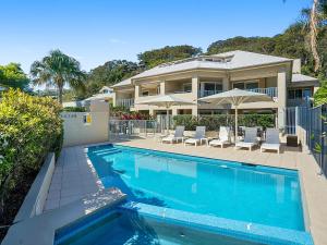 a house with a swimming pool in front of a house at Sunchaser at Iluka Resort Apartments in Palm Beach
