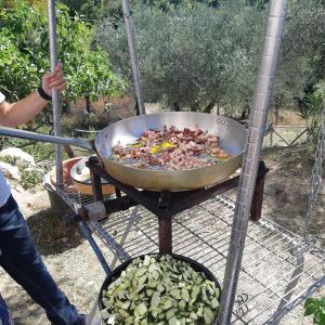 a person cooking food in a pot on a grill at la masseria di Antonio e Teresina in Colli al Volturno