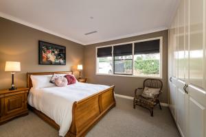 a bedroom with a large bed and two windows at Hedge House - luxury, space, style, great location in Toowoomba