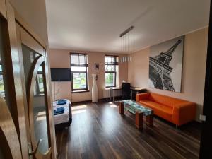 ein Wohnzimmer mit einem orangenen Sofa und dem Eiffelturm in der Unterkunft Willa Vasco in Rewa