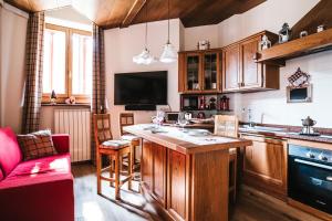 cocina con armarios de madera y sofá rojo en THE NEST Apartment Suite Ski-in Ski-out with Hammam, en Breuil-Cervinia