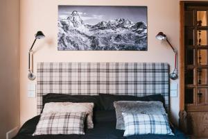 ブレウイル・チェルヴィナイアにあるTHE NEST Apartment Suite Ski-in Ski-out with Hammamのベッドルーム1室(ランプ2つ、壁に絵付)