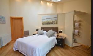 a bedroom with a white bed and a painting on the wall at Silvergrove Apartment in E Sussex in Newick