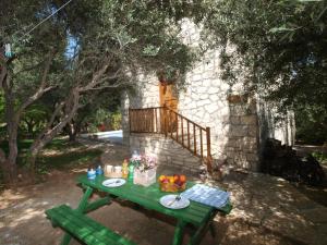 un tavolo da picnic verde con un cesto di frutta di Gerolakos Country Houses a Stavromenos