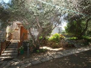 a house with a tree and a stone wall at Gerolakos Country Houses in Stavromenos +12 photos