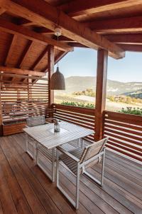 porche de madera con mesa y sillas en la cubierta en Maso Caliari en Bono