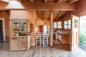 a kitchen with wooden cabinets and a table and chairs at Maso Caliari in Bono