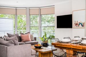 a living room with a couch and a table at Byron Bay Hotel and Apartments in Byron Bay