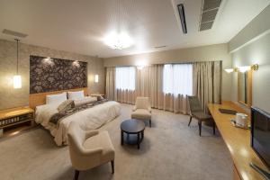Hachinohe Park Hotel في هاتشينوه: غرفة فندق بسرير كبير وتلفزيون