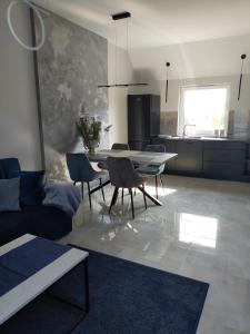 een woonkamer met een tafel en stoelen en een keuken bij Apartament - Come in in Lubin