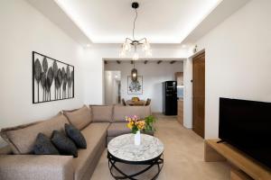 salon z kanapą i stołem z kwiatami w obiekcie Zen Luxury Home, Family Sea Escape! w mieście Magnisía