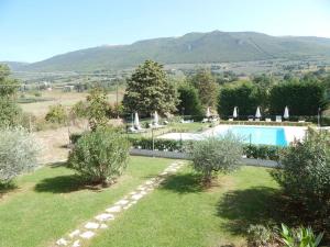 a villa with a swimming pool and mountains in the background at Ostello Victor Center in Capodacqua