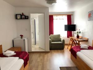 a room with two beds and a chair and a mirror at Pension Rote Rosen in Seesen