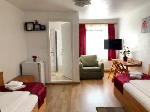 Zimmer mit 2 Betten, einem Stuhl und einem Spiegel in der Unterkunft Pension Rote Rosen in Seesen