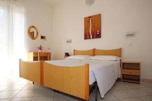 sypialnia z dużym łóżkiem z białą pościelą w obiekcie Hotel Serafini w mieście Misano Adriatico