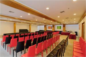 a conference room with red and black chairs and tables at Hi 5 Hotel & Experience in Nashik