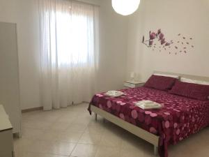 バレストラーテにあるCasa Vacanze Fabrizioのベッドルーム1室(紫のシーツが敷かれたベッド1台、窓付)