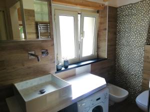 a bathroom with a sink and a toilet and a window at Casa Vacanza L'Ulivo in Albenga