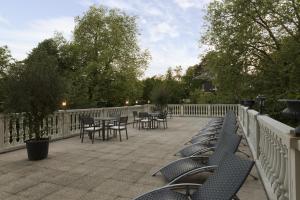 a patio with chairs and tables and a fence at Belle Isle Sur Risle - Chateau Hotel & Spa in Pont-Audemer