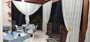 un patio con mesas, sillas y una cortina en B&B Leonida, en Taranto