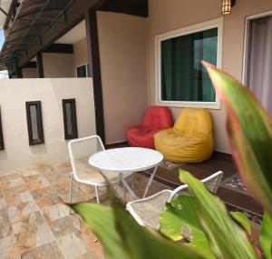 a patio with a table and chairs and a couch at Destini Akef Villa in Pantai Cenang