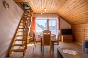 a room with a table and a spiral staircase in a house at Ferienwohnung Monika Haug in Immenstaad am Bodensee