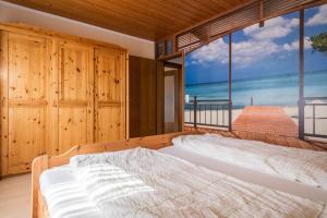 a bedroom with a bed with a view of the beach at Ferienwohnung Monika Haug in Immenstaad am Bodensee