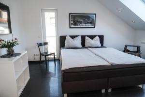 um quarto com uma cama e uma parede branca em Modern Loft/Apartment near Bonn DTAG/DHL/UN em Königswinter