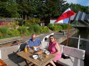 un hombre y una mujer sentados en una mesa en un barco en Maz glaz en Nantes