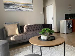 a living room with a couch and a table at Spring Acres Apartment living in Nelspruit