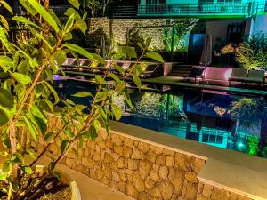 una piscina con sedie e una pianta accanto ad essa di Apartments Secret Garden a Ulcinj