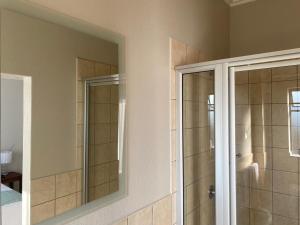 a bathroom with a shower and a mirror at Spring Acres Apartment living in Nelspruit +7 photos