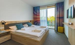 ein Schlafzimmer mit einem großen Bett in einem Zimmer in der Unterkunft Akadémia Hotel in Balatonfüred