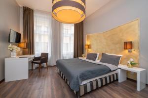 a bedroom with a bed and a desk and a television at Emporio Prague Apartments in Prague