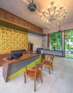 Habitación grande con escritorio, sillas y lámpara de araña. en Anchan Boutique Hotel- SHA Plus, en Chalong 