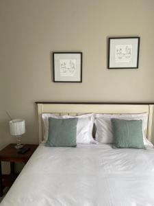 a large white bed with two pictures on the wall at Spring Acres Apartment living in Nelspruit