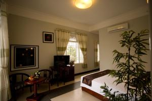 a bedroom with a bed and a plant in it at The Moon Villa Hoi An in Hoi An