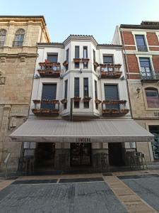 レオンにあるARVA Spa Parísの正面に日よけのある大きな白い建物