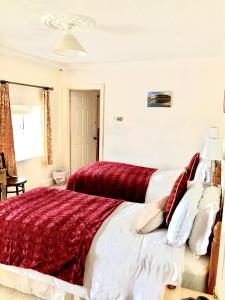 a bedroom with a large bed with red and white pillows at Dufferin Coaching Inn in Killyleagh