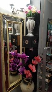 a mirror and a vase with flowers in a room at City View Hotel Roman Road in London