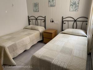 - une chambre avec 2 lits et une table de nuit en bois dans l'établissement Edificio Prieto VIV 5, à Puerto del Rosario
